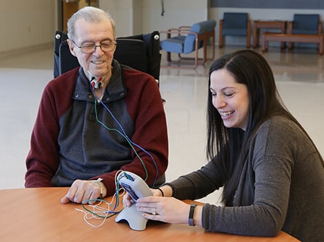 A rehabilitation therapist aids a stroke survivor using the Armeo Spring.