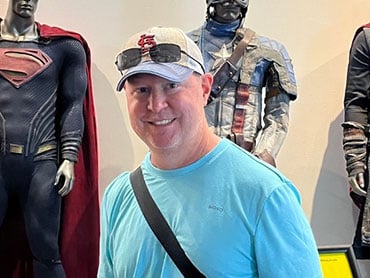 Stephen Allbright standing wearing a blue shirt and hat.