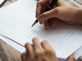Patient writing on an invoice.
