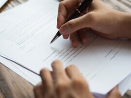 Patient writing on an invoice.