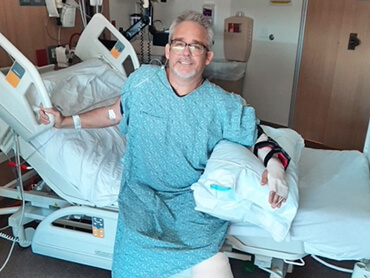 Brian sitting on the edge of his hospital bed.