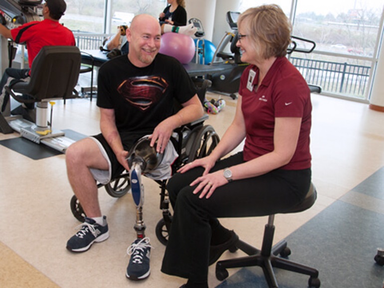 female therapist working with a male amputee patient