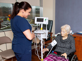 therapist taking blood pressure of an older patient