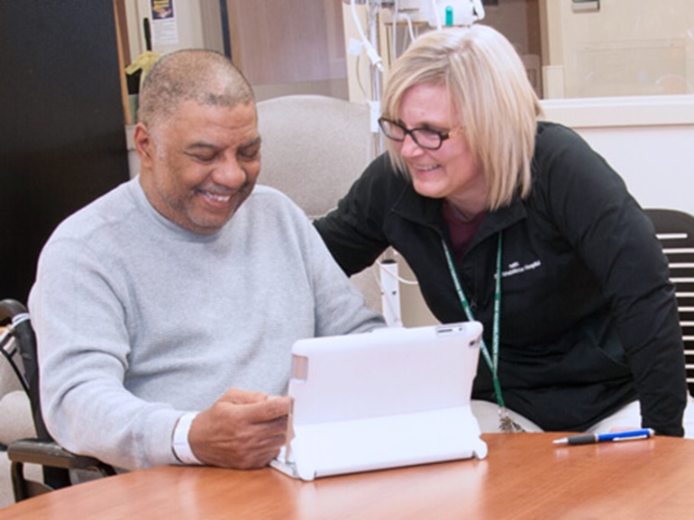 therapist and patient viewing a tablet