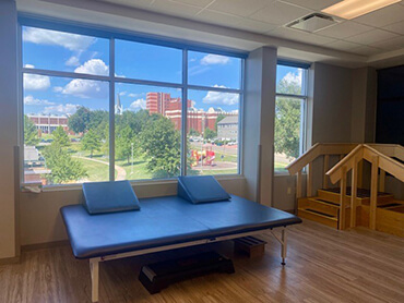A room with therapy bench in front of a large window.