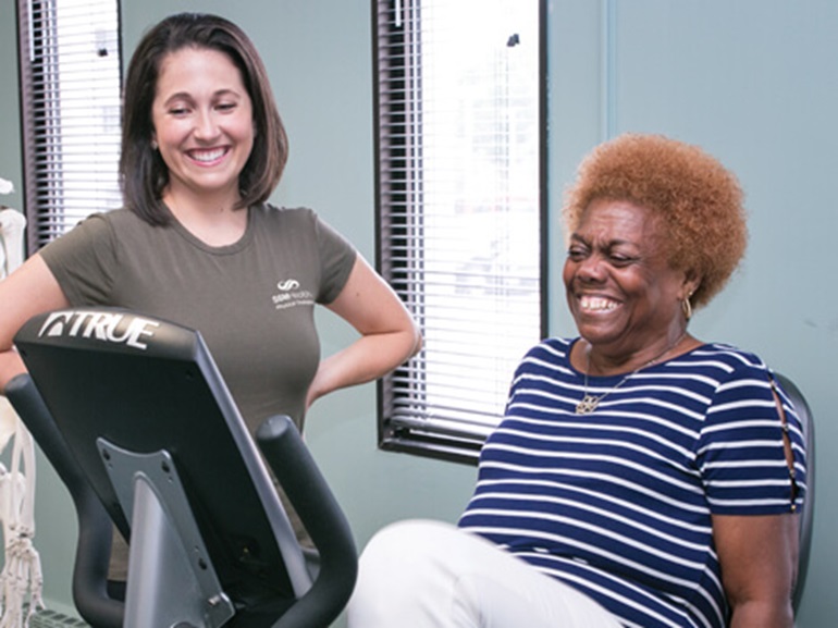therapist with patient on an exercise bike