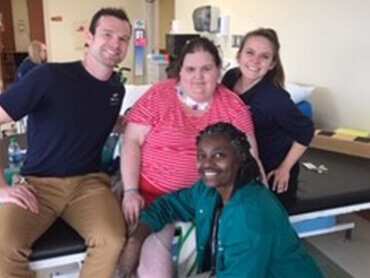 Riana Evans sitting with 3 of her physical therapists.