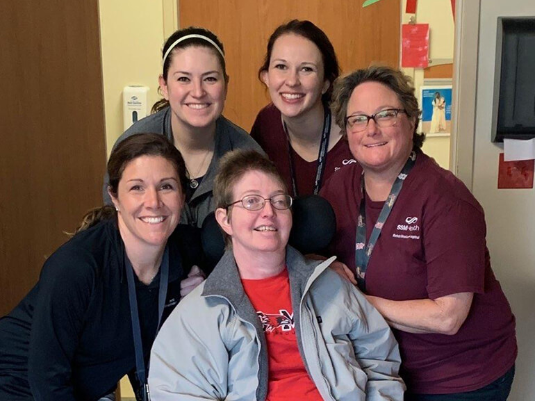 Patient Christina Gass poses with 4 of her physical therapists.