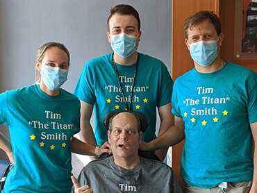 Patient Timothy Smith poses with 3 of his physical therapists.