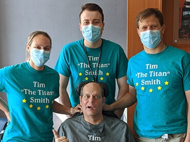 Patient Timothy Smith poses with 3 of his physical therapists.