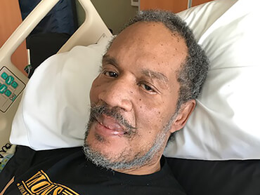 Patient Frederick Sanders lying in a hospital bed.
