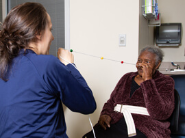 Therapist and patient each holding end of cord with colored markers