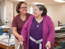 Physical therapist working with a patient who is using a walker.